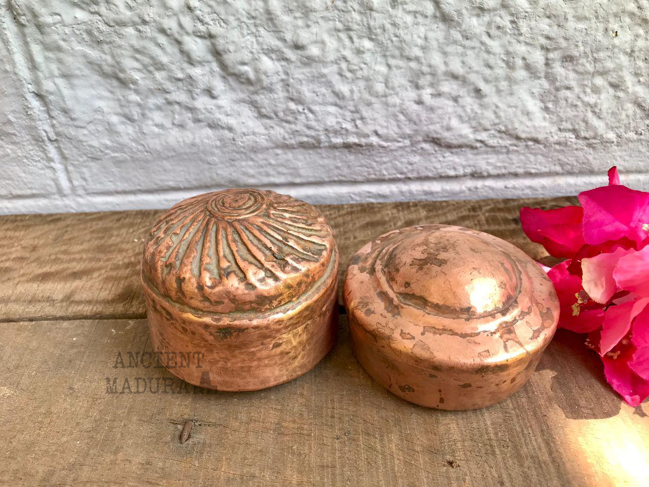 A set of two round copper storage boxes
