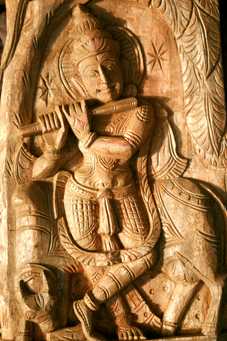 Lord Krishna with Cow Surabhi Carved onto a wooden panel