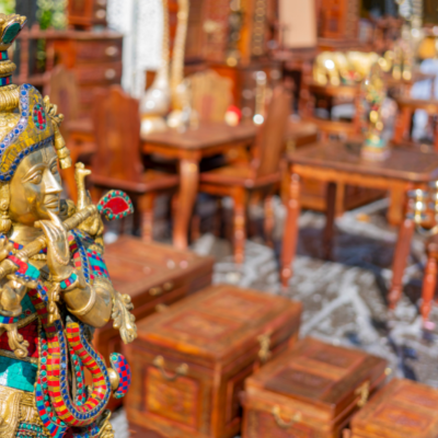 Peek into a store with Indian themed wooden furniture and brass statues