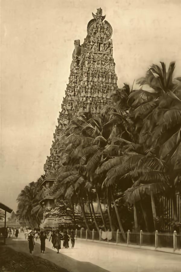 A perspective of the Meenakshi Amman temple tower and street with the devotees scattered about