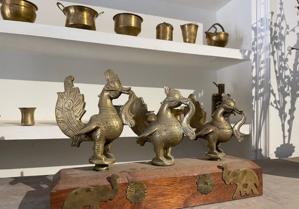 Shopping antiques in madurai : A wooden panel of Annapakshi bird figurines and miniature vessels lined up on the shelves