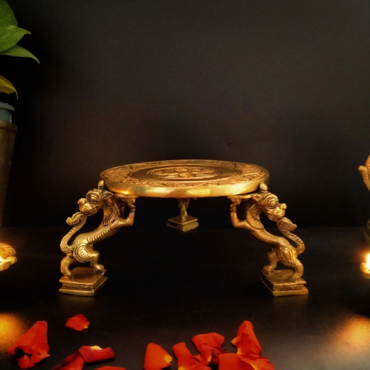 A brass pooja stand with yazhi shaped legs