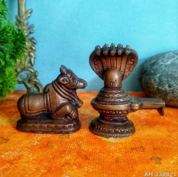 A copper Nandi Statue facing a copper Shivalingam