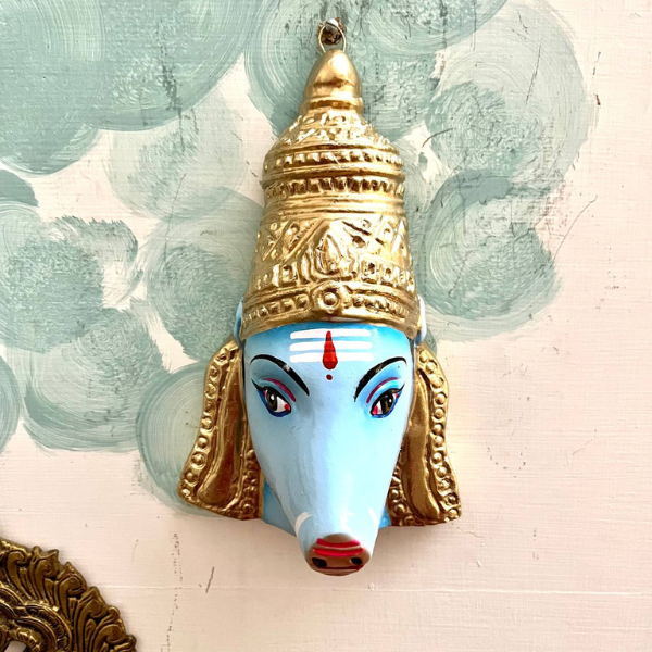 Varahi Amman Statue : A Varahi Amman Mask that is painted blue with gold detailing on the crown