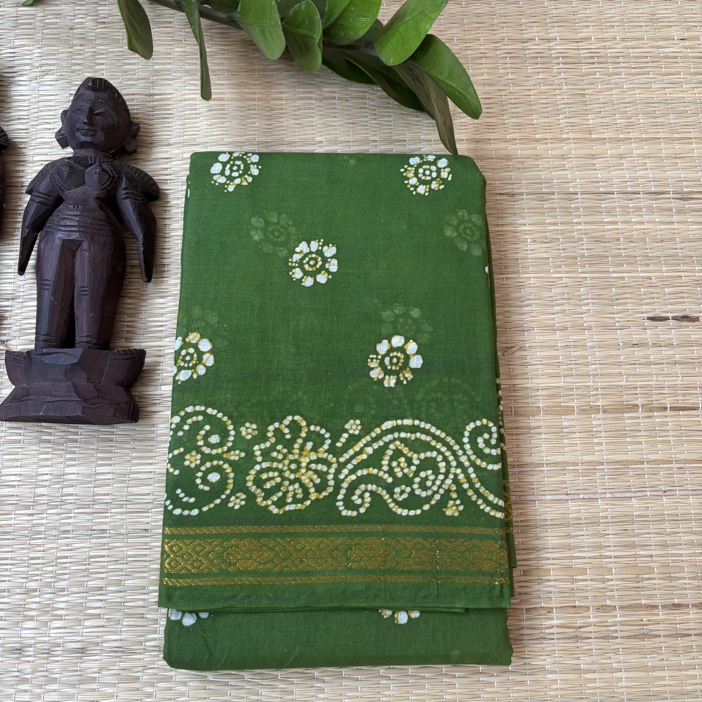 Leaf green sungudi batik saree with white and gold floral rosette motifs and elaborate vine scroll pallu