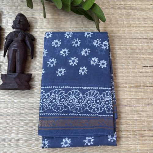 Slate blue sungudi batik saree with white floral rosette motifs, gold zari border and framed floral pallu with wave accents