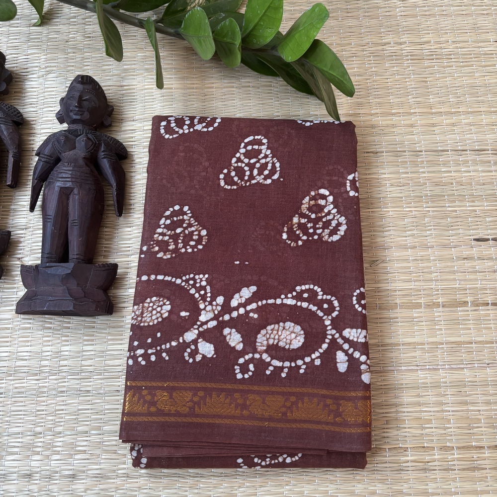 Brown sungudi batik saree with white tricircle cluster motifs, mango border and elaborate vine pallu