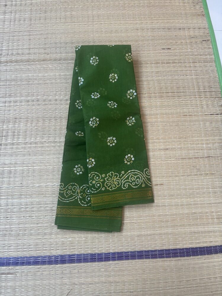 Leaf green sungudi batik saree with white and gold floral rosette motifs and elaborate vine scroll pallu