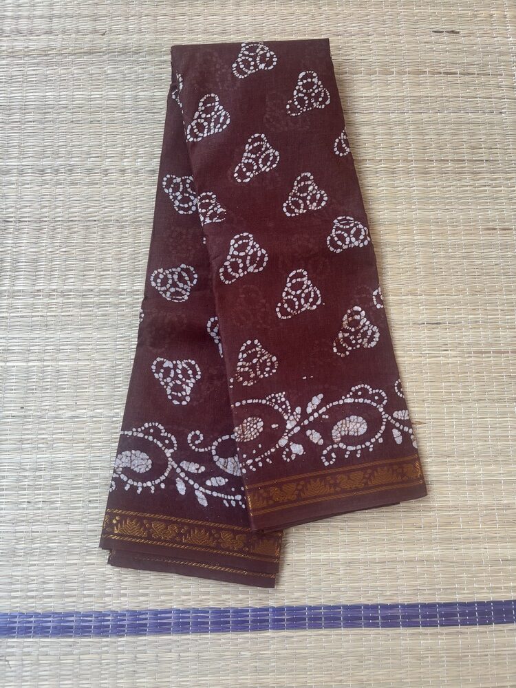 Brown sungudi batik saree with white tricircle cluster motifs, mango border and elaborate vine pallu