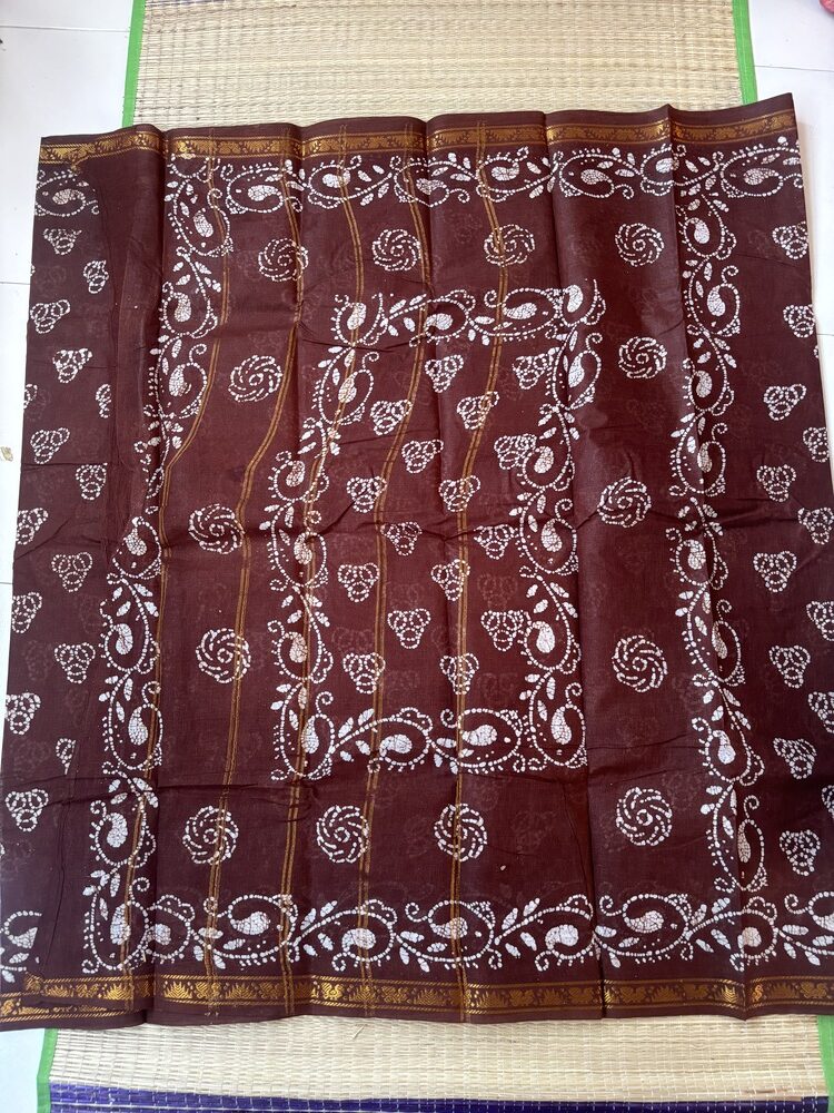 Brown sungudi batik saree with white tricircle cluster motifs, mango border and elaborate vine pallu